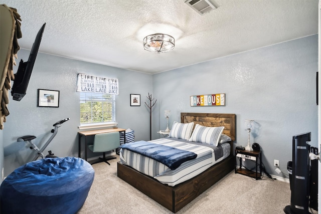 bedroom featuring visible vents, carpet floors, a textured ceiling, and a textured wall