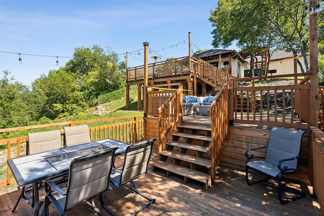 wooden terrace featuring outdoor dining area and stairs