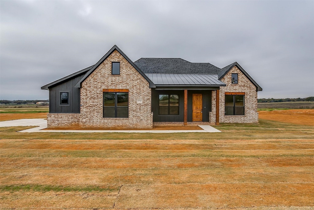 view of front of house with covered porch and a front lawn