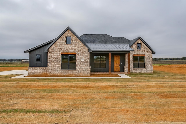 view of front of house with covered porch and a front lawn