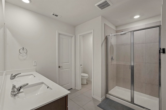 bathroom featuring vanity, toilet, an enclosed shower, and tile patterned floors