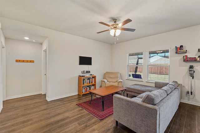 living room featuring dark wood-type flooring and ceiling fan