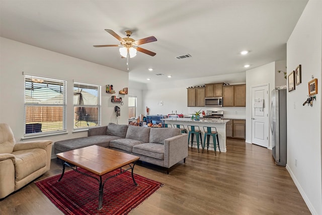 living room featuring dark hardwood / wood-style flooring and ceiling fan