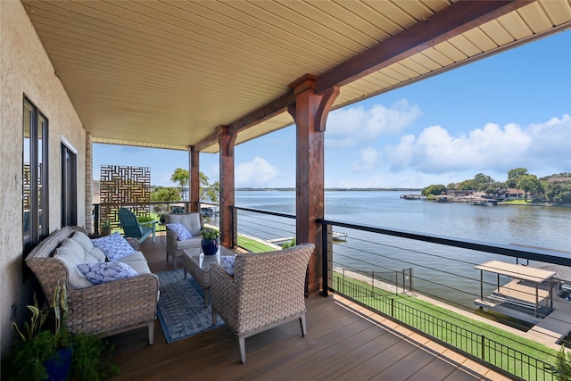 deck with an outdoor living space and a water view