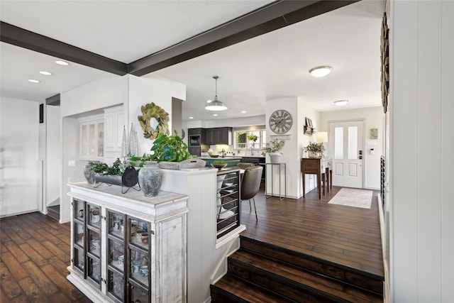 kitchen with beam ceiling, a kitchen breakfast bar, and dark hardwood / wood-style flooring