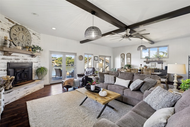 living room featuring beamed ceiling, a fireplace, plenty of natural light, and dark hardwood / wood-style floors