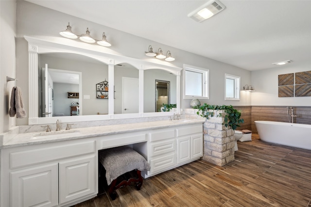 bathroom with vanity, a tub to relax in, and hardwood / wood-style flooring