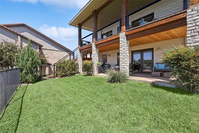 view of yard with a balcony and a patio