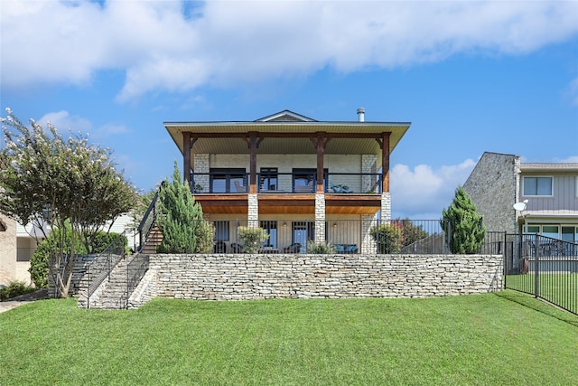 rear view of house featuring a yard and a balcony