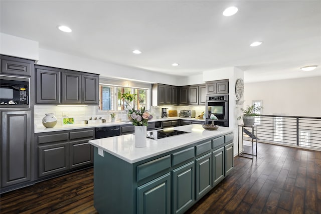 kitchen with black appliances, dark hardwood / wood-style flooring, tasteful backsplash, and a kitchen island