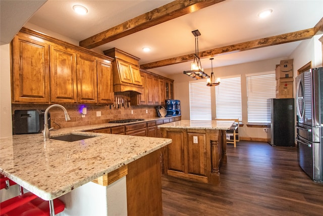 kitchen featuring stainless steel appliances, a kitchen breakfast bar, a kitchen island, sink, and dark hardwood / wood-style floors