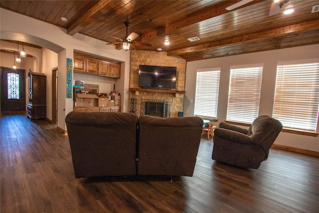 living room with a fireplace, beamed ceiling, ceiling fan, dark hardwood / wood-style floors, and wood ceiling