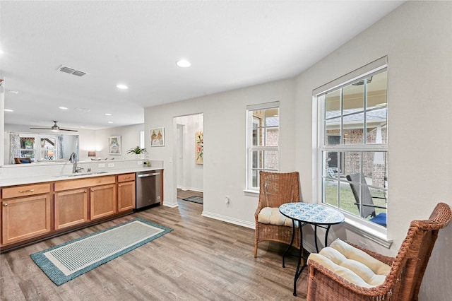 kitchen featuring dishwasher, ceiling fan, sink, and light hardwood / wood-style flooring