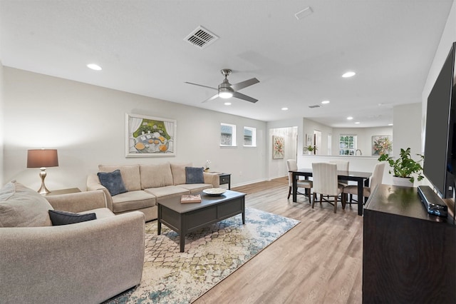 living room featuring ceiling fan and light hardwood / wood-style floors