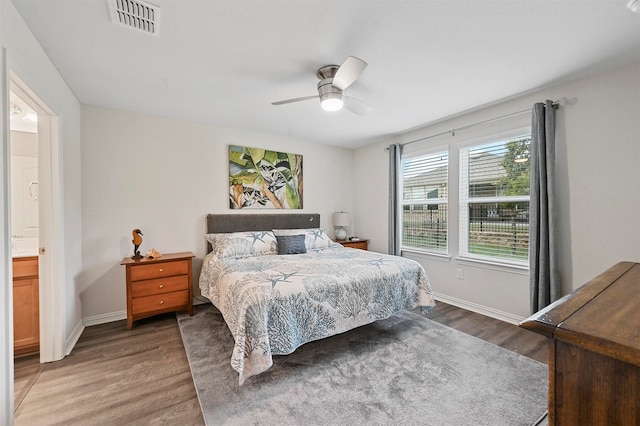 bedroom featuring ensuite bath, dark hardwood / wood-style flooring, and ceiling fan