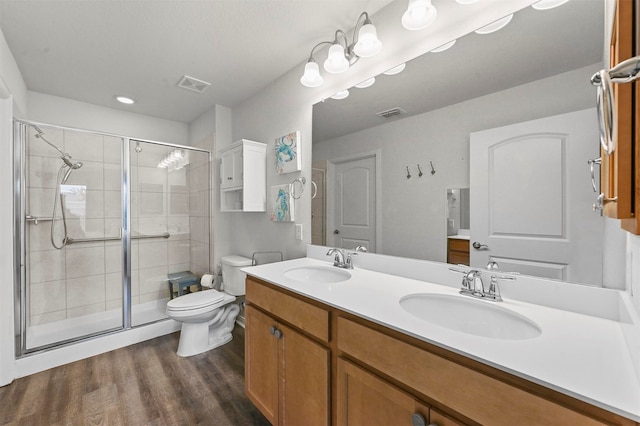 bathroom with vanity, toilet, hardwood / wood-style flooring, and a shower with shower door