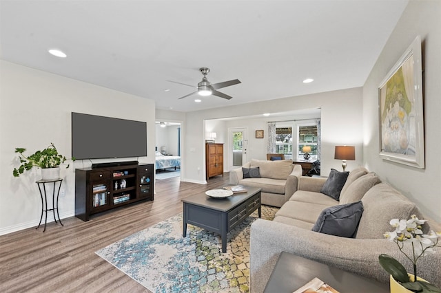 living room featuring hardwood / wood-style floors and ceiling fan