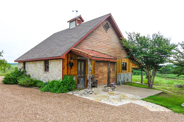 rear view of house featuring a lawn and a garage