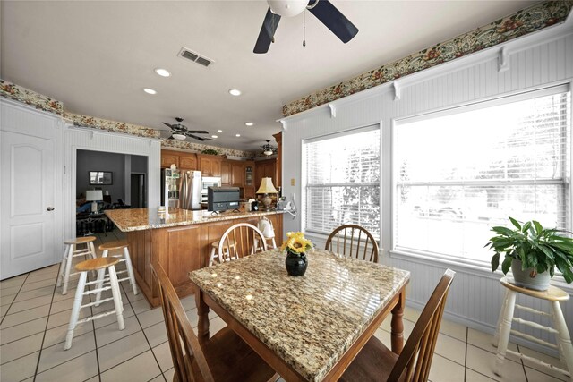 tiled dining area with ceiling fan and a healthy amount of sunlight