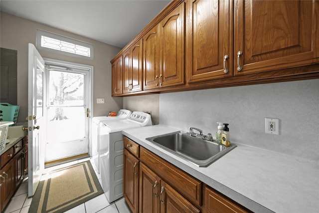 clothes washing area featuring light tile patterned floors, electric panel, sink, separate washer and dryer, and cabinets