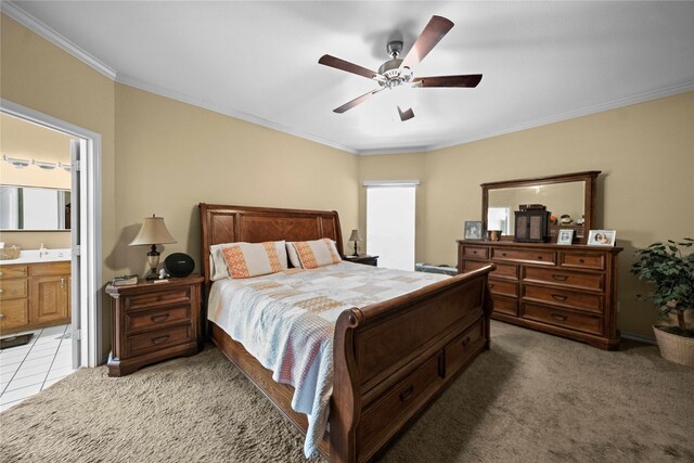 bedroom with crown molding, ensuite bath, light colored carpet, sink, and ceiling fan