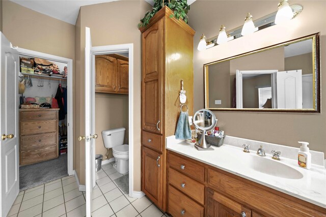 bathroom with tile patterned flooring, vanity, and toilet