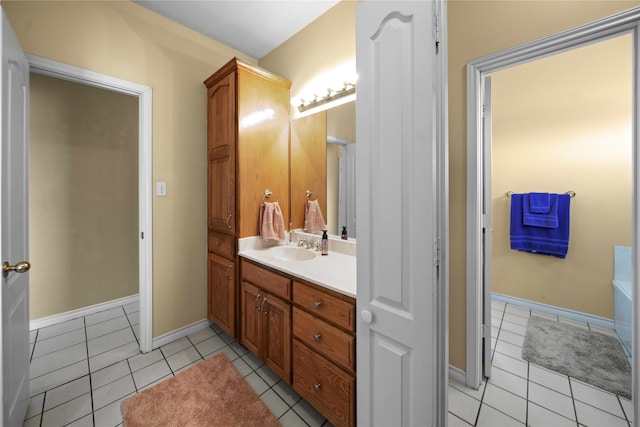 bathroom with tile patterned flooring, a tub to relax in, and vanity