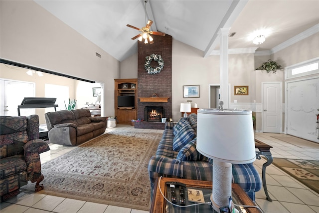 living room featuring a fireplace, ceiling fan, decorative columns, light tile patterned flooring, and high vaulted ceiling