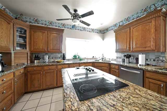 kitchen with stainless steel dishwasher, ceiling fan, sink, and light stone countertops