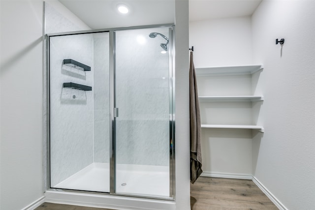 bathroom featuring hardwood / wood-style flooring and a shower with shower door