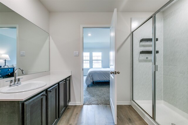 bathroom featuring walk in shower, vanity, and hardwood / wood-style floors