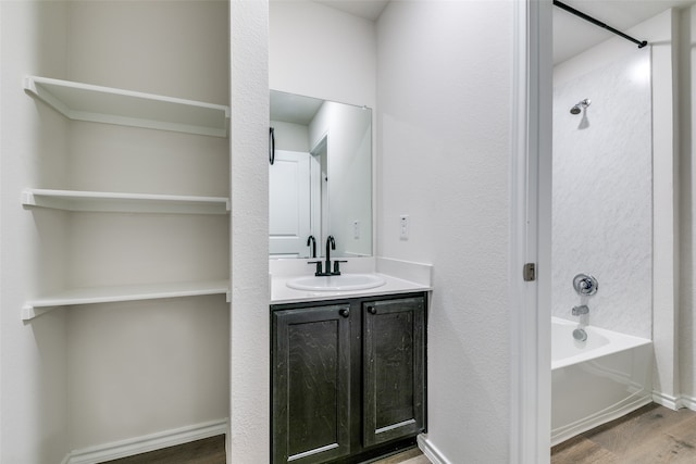 bathroom featuring hardwood / wood-style flooring, shower / washtub combination, and vanity