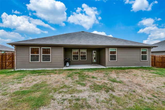 rear view of property featuring a yard and a patio