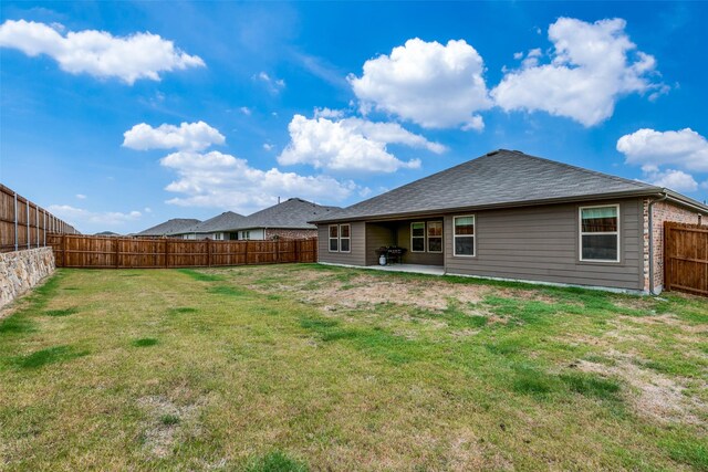 rear view of house with a patio area and a lawn