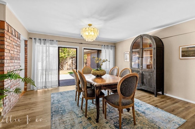 dining room featuring a chandelier, light hardwood / wood-style floors, and crown molding