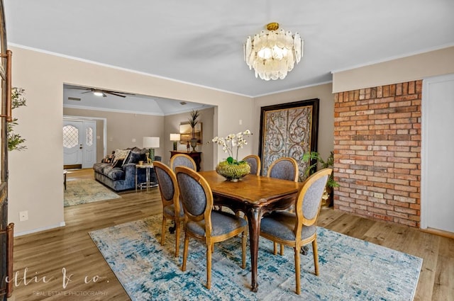 dining area featuring ceiling fan with notable chandelier, crown molding, and hardwood / wood-style floors