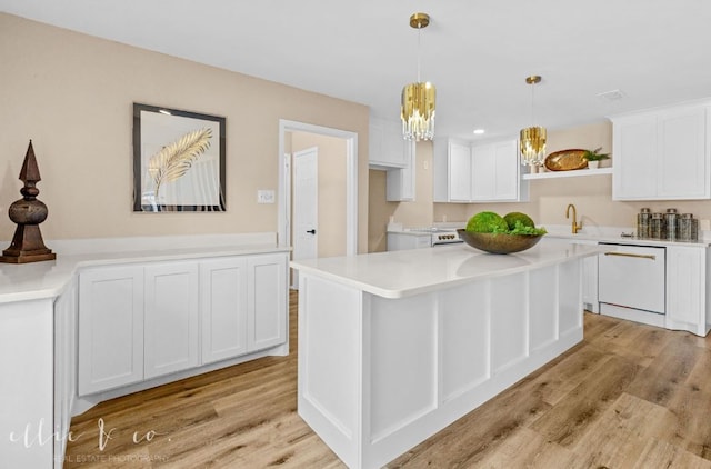 kitchen with light wood-type flooring, white appliances, white cabinets, and hanging light fixtures