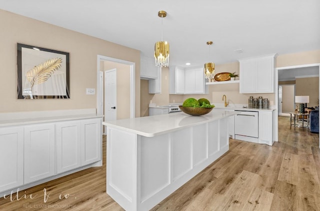 kitchen featuring white appliances, a kitchen island, white cabinets, and light hardwood / wood-style floors