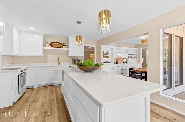 kitchen featuring white cabinets, light hardwood / wood-style flooring, decorative light fixtures, a notable chandelier, and electric stove