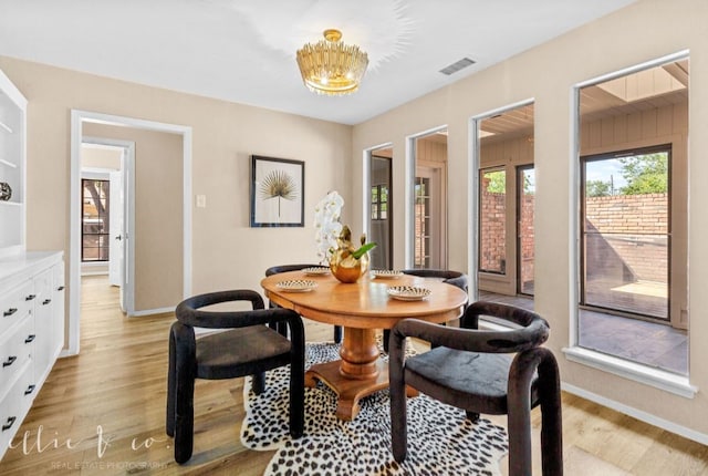 dining room featuring light hardwood / wood-style flooring and a chandelier