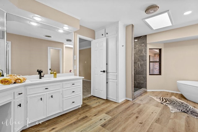 bathroom featuring vanity, hardwood / wood-style floors, and a tile shower