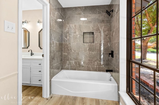 bathroom featuring tiled shower / bath, vanity, plenty of natural light, and hardwood / wood-style flooring