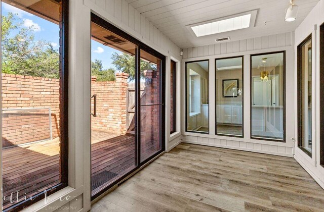 unfurnished sunroom with a skylight