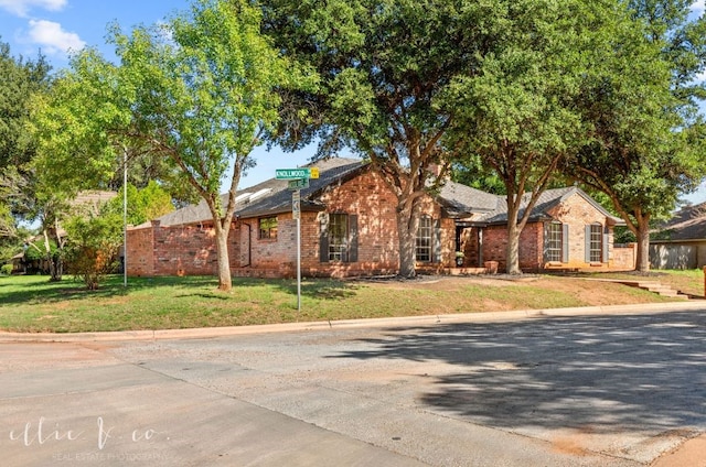 single story home featuring a front lawn