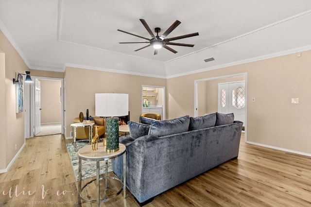 living room with ornamental molding, light hardwood / wood-style flooring, and ceiling fan