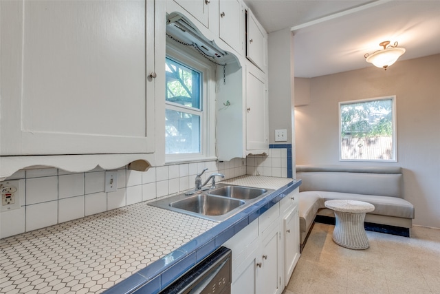 kitchen with white cabinetry, tile countertops, sink, and decorative backsplash