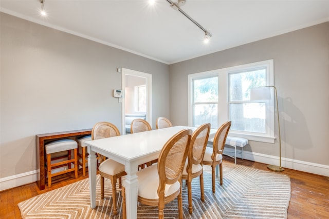 dining room featuring track lighting, light hardwood / wood-style floors, and crown molding