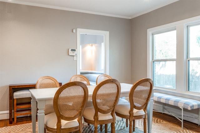 dining area featuring hardwood / wood-style flooring and crown molding