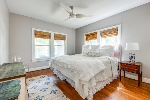 bedroom featuring multiple windows, ceiling fan, and wood-type flooring