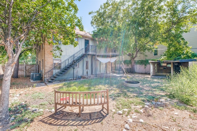 view of yard featuring a fire pit and central AC